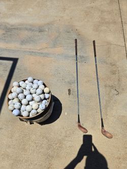 Bucket of golf balls with golf clubs