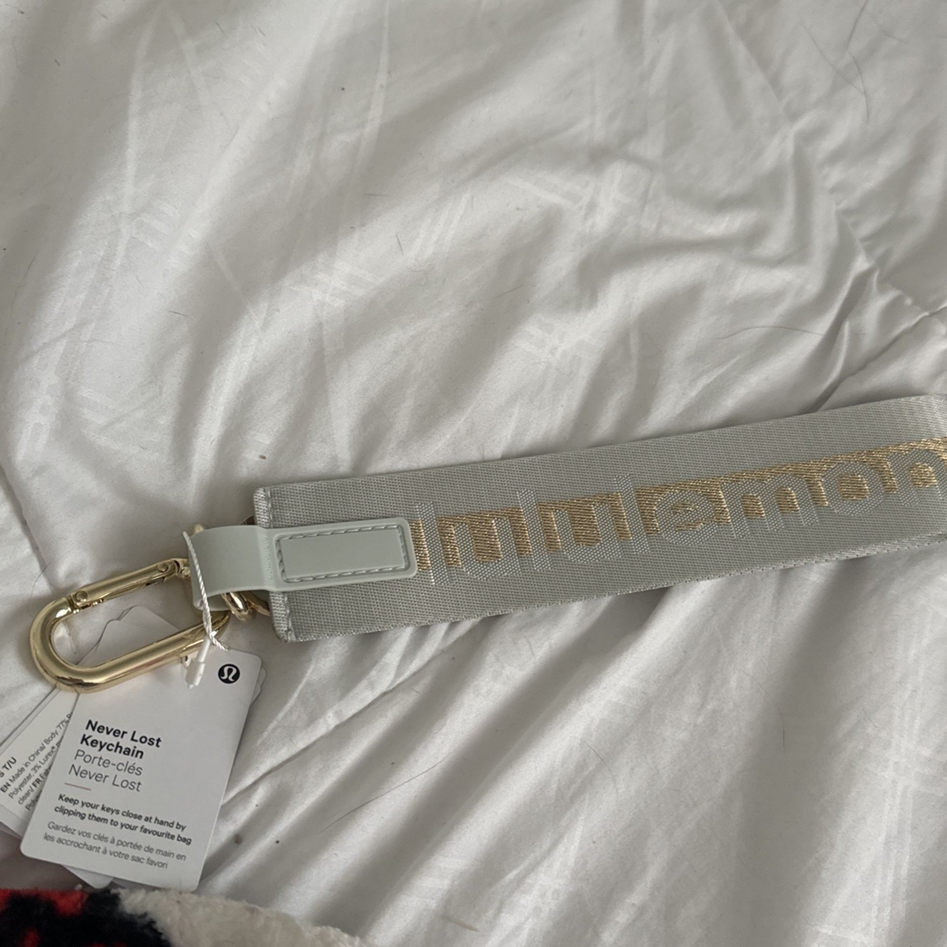 white and gold lululemon keychain