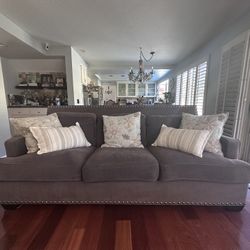 Elegant Gray Upholstered Sofa with Nailhead Trim (2) & Decorative Pillows