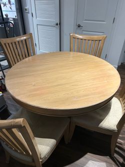 Round wood dining table with 4 matching chairs.