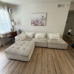 White sectional sofa, sturdy but needs cleaning. Has spots and minor wear.