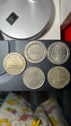 displays a collection of five vintage one-dollar casino gaming tokens from historic hotel and casinos