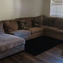 Beige-Gray Couch With Decorative Pillows And Rug