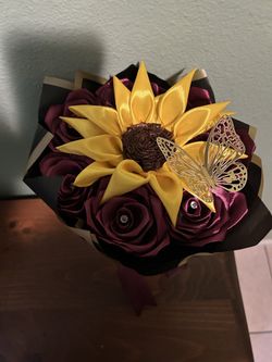 Lindo ramo  de rosas color morado con un girasol Enel dentro