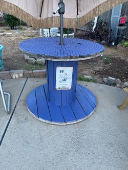 Rustic shabby outdoor spool wood table with bottle cap nailed on top- 39.5 inches wide/ 32 inches high holds umbrella in middle  - umbrella not includ