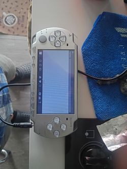 Sony PSP 2000 (no battery, severely broken) with charging cord and UMD video game