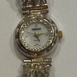 These are women's quartz watches from the Arenix brand in a vintage style. The watch features a two-tone metal bracelet and an oval dial with crystals