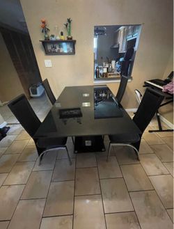 Black glass dining room table with matching chairs included