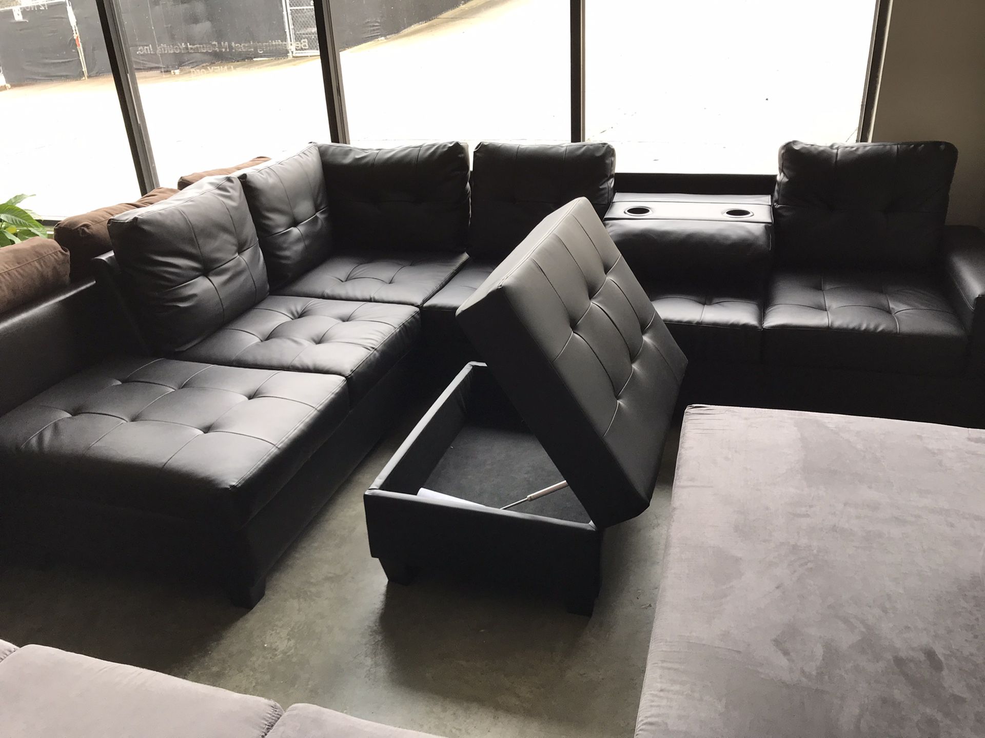 Black leather sectional with ottoman storage