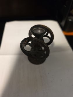 miniature decorative replica of an antique double-wheel cast-iron coffee grinder features a dark bronze-toned metal finish and a classic dual-flywheel
