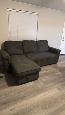 Dark grey sofa bed with storage compartment