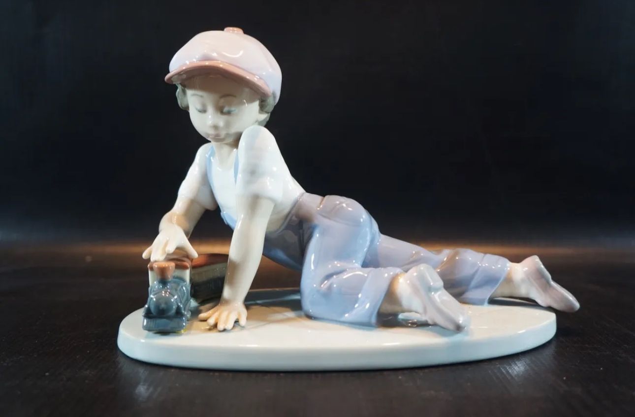 Lladro Figurine, 7619 All Aboard, Boy with Train Toy.