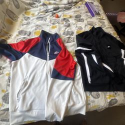 2 nike turtle necks and black valabasas pants and a red nike duffle bag