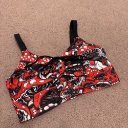Soft, supportive top in a vibrant red mushroom print. Adjustable straps and a front tie for a customizable fit. Smooth fabric designed for everyday co
