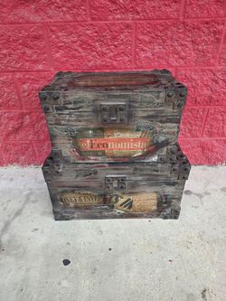 Pair of vintage style decorative wood trunks with dark distressed wood construction and reinforced metal corner details