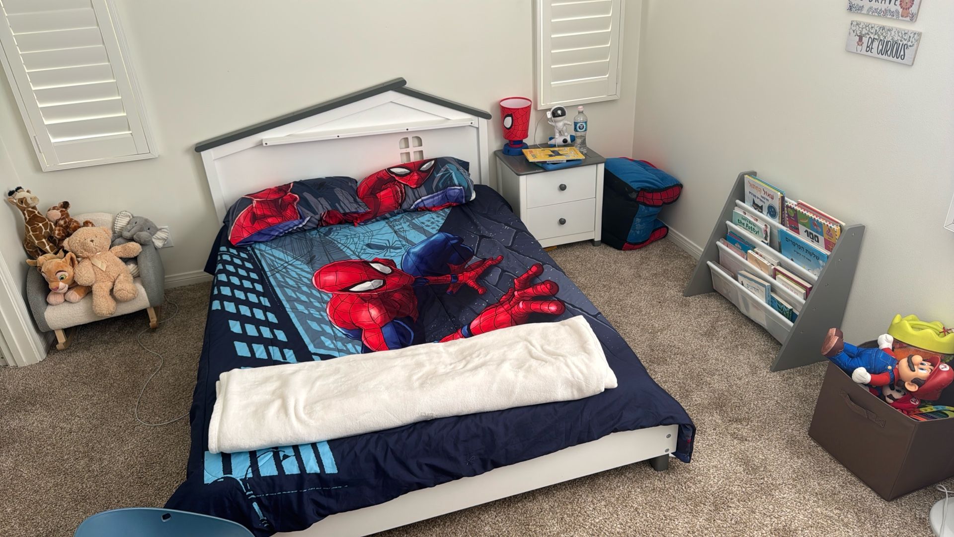 A room full of sleeping space for a child, a sofa bed, a wardrobe and bookshelves