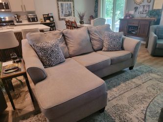 Ashley 88" light gray sofa with pillows.