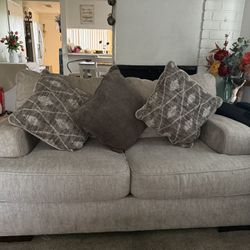 beige love couch with pillows 