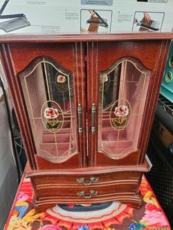 MCM Jewelry Armoire with two glass doors and two drawers.  Measurements are 16 1/2"h  x 11 1/2w x 6 "depth.  It's in very great condition.  See photos