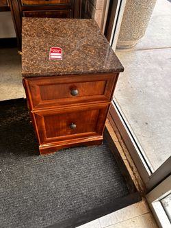 Elegant wooden nightstand or side table with a dark marble-patterned top