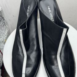 These are black leather Nine West mules with a white stripe.