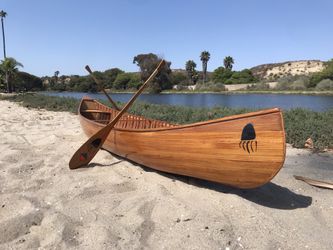 Hand-Crafted Chippewa Tribe Wooden Canoe with twin paddles.