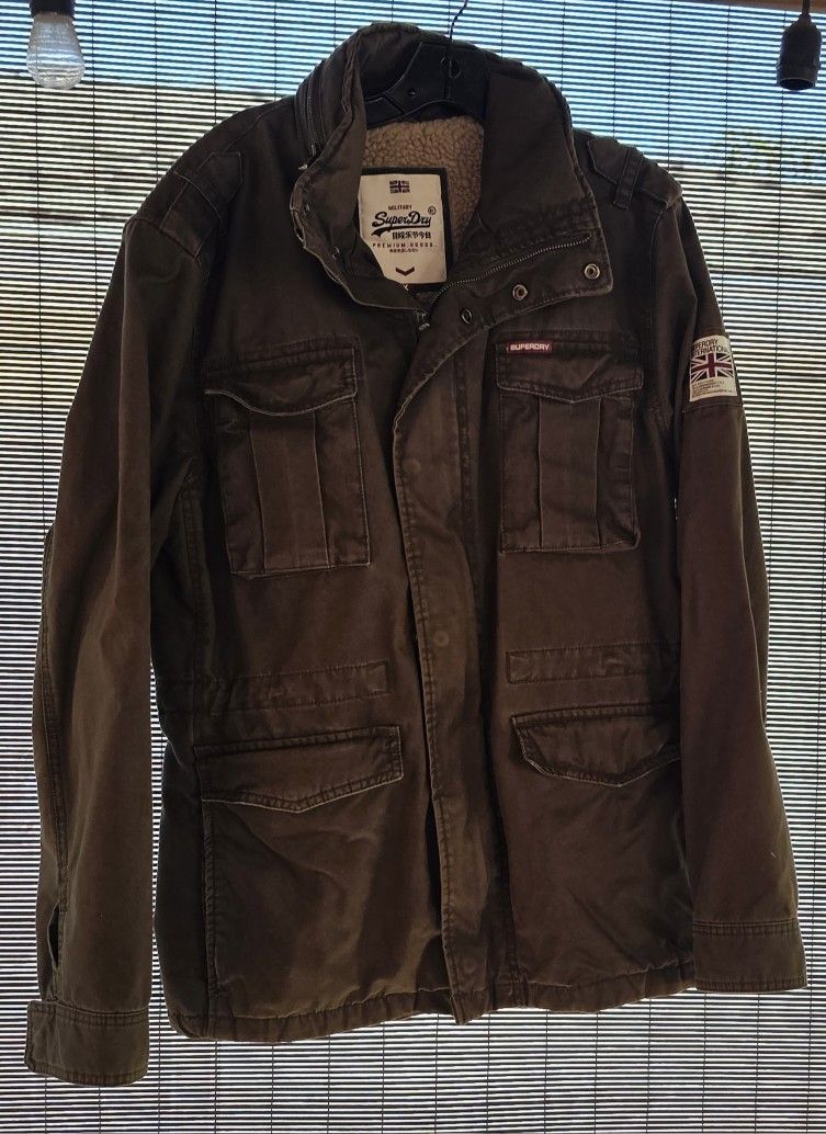 Superdry men’s Rookie heavy weather field jacket. This fleece lined jacket features four front pockets button and popper fastening and buttoned cuffs.