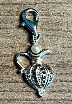 Elegant silver-stamped 925 perfume bottle charm with a cultured pearl accent. Designed for bracelets or necklaces to add a delicate, feminine touch. F