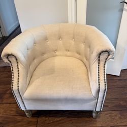 Linen-upholstered barrel chair in a tan color