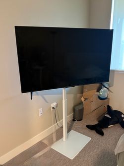Large Flat Screen TV with White Floor Stand