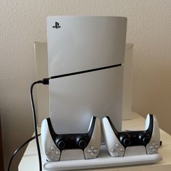 Sony PlayStation 5 with two game controllers and stand