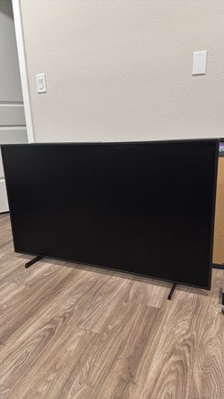 55” Samsung Frame TV with stand and wood frame bezel.