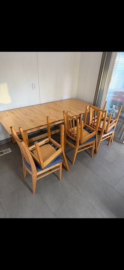 Versatile Extendable Light Wood Dining Table with Six Blue Upholstered Chairs