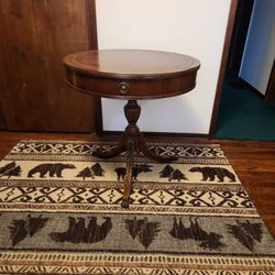 Duncan Phyfe-style mahogany drum table with a leather top and a pedestal base.