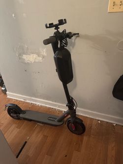 Electric scooter with charger, bag, phone holder, and lock.