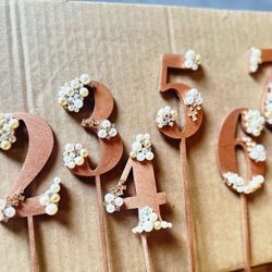 8 wooden copper rose gold painted table pic numbers with pearl and crystal accents  2 have extender pieces taped to them that can be removed 