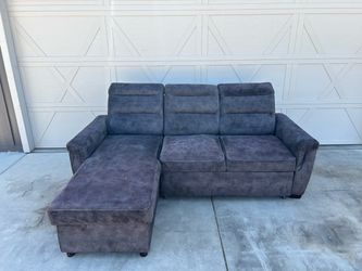 Dark Grey Sectional with Storage and Rollout Ottoman