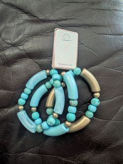 Set of 3 stackable elastic bracelets with blue beads and gold-tone spacers.