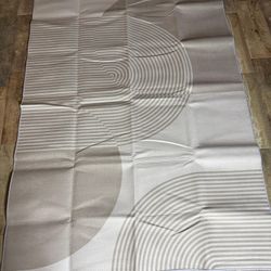 Atticgo Flora rug, a machine-woven rug known for its modern geometric design and neutral gray and white/cream tones.