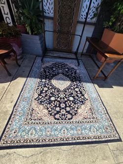 rug that resembles the classic Persian Nain style, with its characteristic blue and cream central medallion