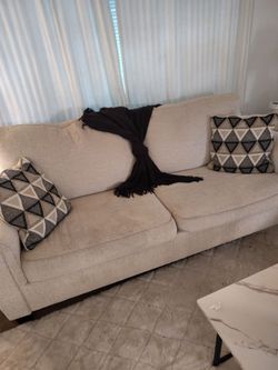 Cream colored sofa and loveseat