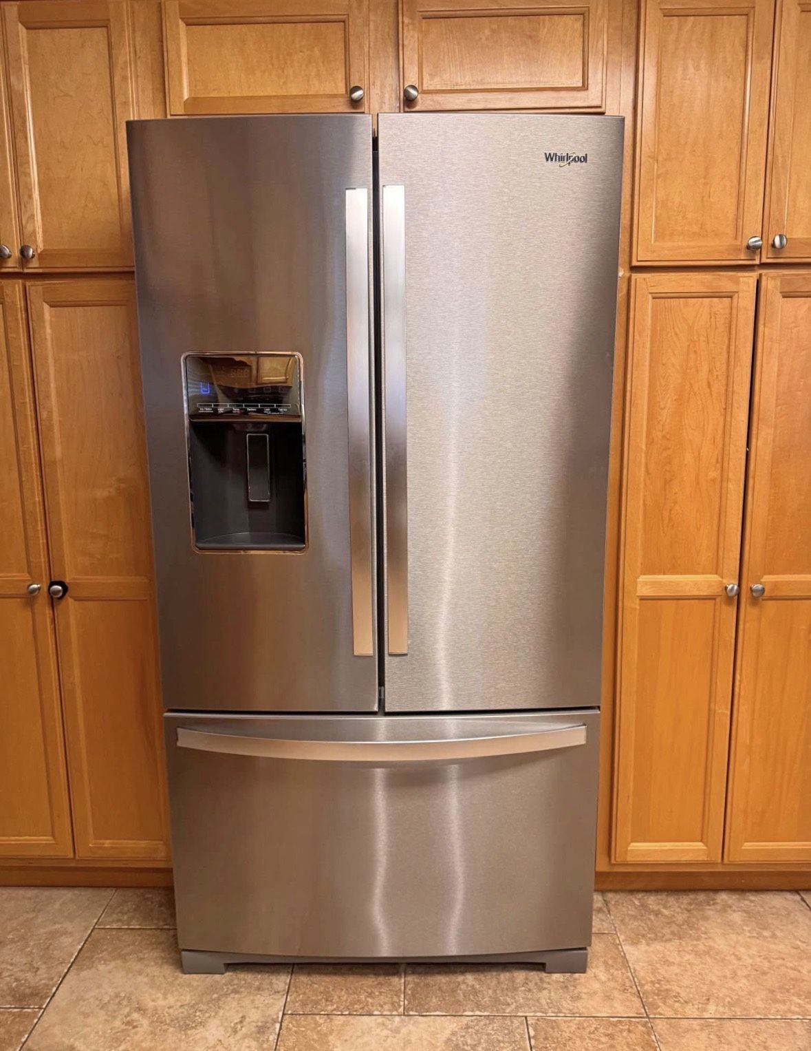 Whirlpool French door refrigerator with water dispenser and dual ice makers.