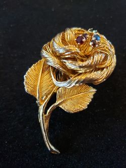 $20. Vintage gold tone flower/5 rhinestones brooch made by Direction One. 2 inch long by 1 inch wide.