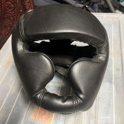 Black leather boxing / sparring headgear — Size S Casco negro de boxeo / sparring — Talla S  Leather headguard with chin bar and Velcro back closure. 
