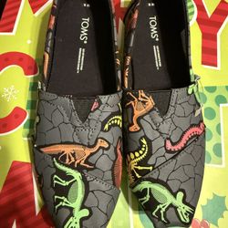 TOMS Alpargata slip-on shoes with a Neon Dino Dig glow-in-the-dark print. 