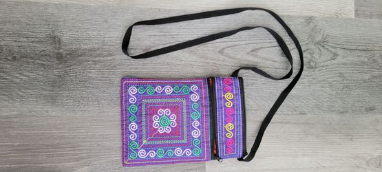purple crossbody pouch features intricate, colorful geometric embroidery