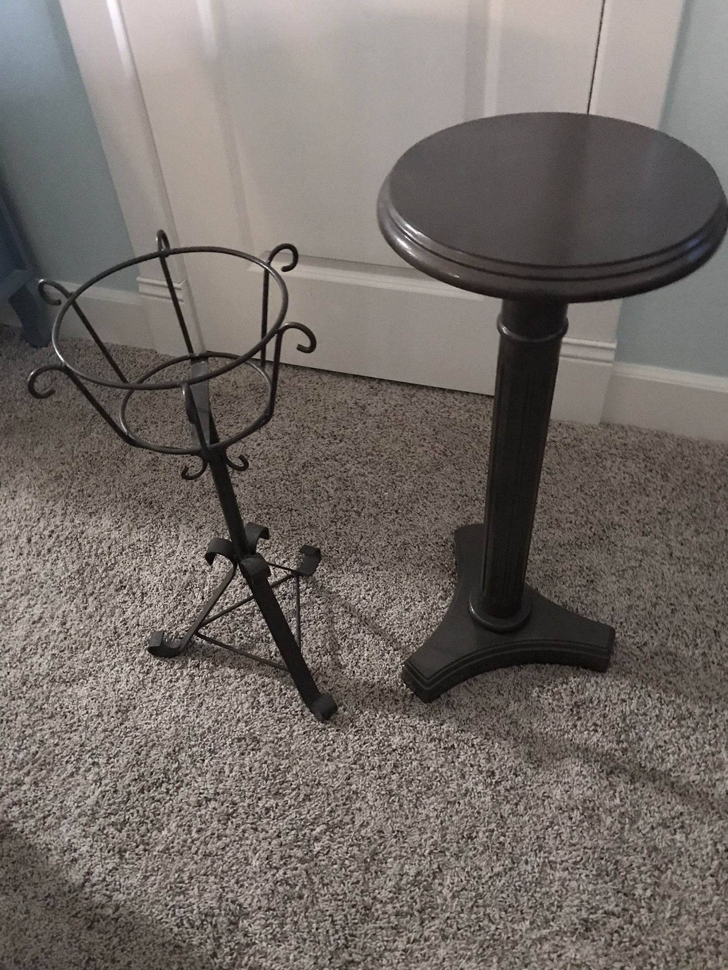 Two plant stands. One metal, one is wooden.