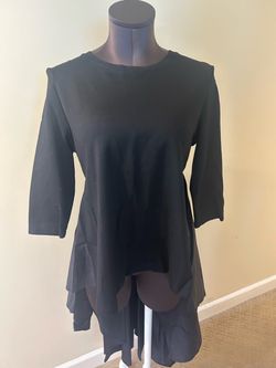 Black layered tunic designed for effortless style. Lightweight fabric with cascading hem adds movement. Three-quarter sleeves for easy, versatile wear