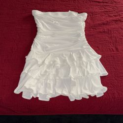  white strapless mini dress with a ruched bodice and a tiered ruffle skirt. 