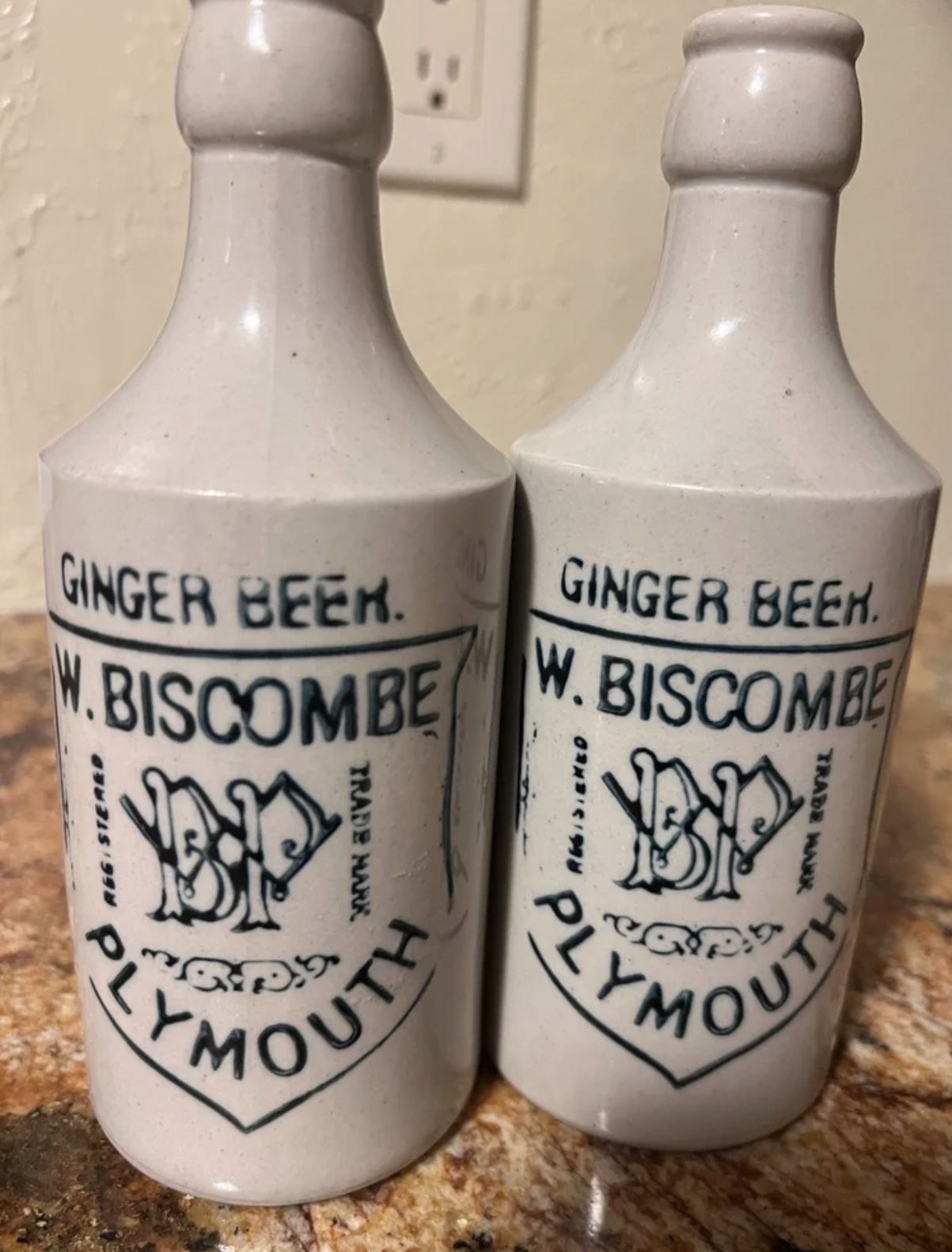 Pair of antique white glazed stoneware W. Biscombe ginger beer bottles